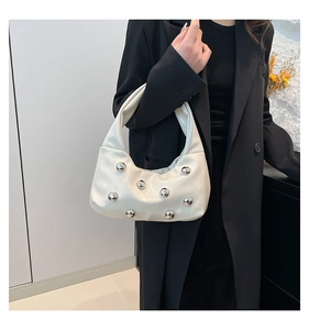 Vue détaillée du sac sous le bras blanc brillant avec rivets métalliques argentés sur un modèle