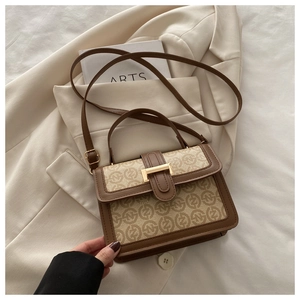 Detail view of vintage patchwork handbag with monogram canvas and gold buckle closure