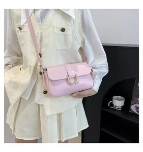 Detail of candy pink crossbody bag with gold U-shaped buckle and adjustable strap