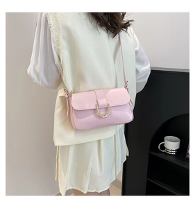 Detail of pink baguette bag showing smooth PU leather texture and golden U-shaped buckle
