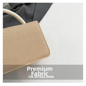 Détail de la texture tissée et de la poignée en cuir crème d'un sac à main élégant