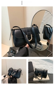 Detail of classic black leather shoulder bag with gold horseshoe buckle and flap closure