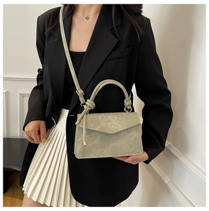 Sage green minimalist crossbody bag with top handle knot detail on female model