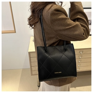 Détail du sac cabas matelassé noir avec lettrage doré sur cuir de haute qualité