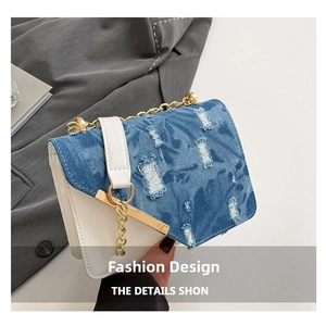 Dettaglio borsa a tracolla in denim blu consumato e pelle bianca con catena d'oro