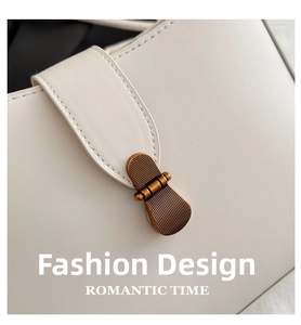 Close-up of premium leather texture and vintage bronze metal buckle on white shoulder bag