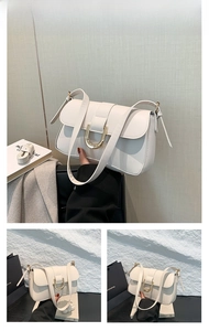Detail of white leather shoulder bag with gold horseshoe buckle and clean stitching