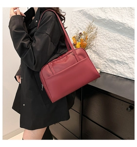 Detail view of burgundy PU leather tote bag worn as an underarm shoulder bag