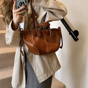 Vue détaillée du sac cabas en cuir marron avec surpiqûres blanches et détails de cordon