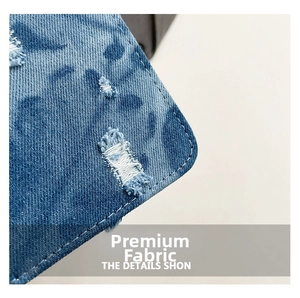 Dettaglio del tessuto denim blu con stampa leopardata, finiture usurate e cuciture