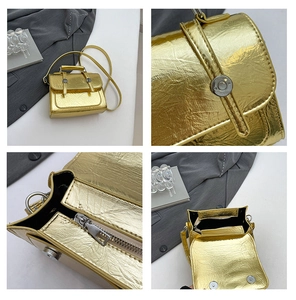 Detail view of gold textured crossbody bag with silver clasp and interior zipper pocket