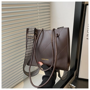 Détail du sac cabas matelassé marron foncé avec bandoulière pied-de-poule et texte doré