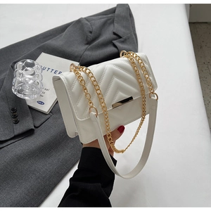 Elegant white quilted crossbody bag with gold chain strap and stylish V-pattern stitching