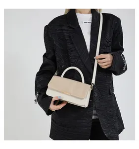 Détail du sac à main contrasté avec texture en paille tressée et fermoir en métal doré