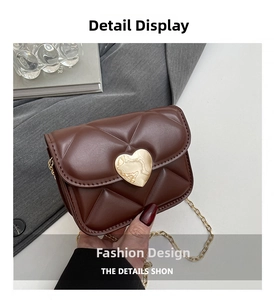 Détail d'un sac bandoulière matelassé marron avec boucle cœur dorée et bandoulière chaîne