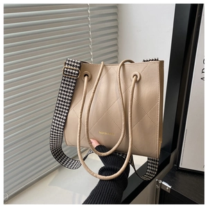 Détail du sac cabas beige matelassé avec bandoulière pied-de-poule et logo doré