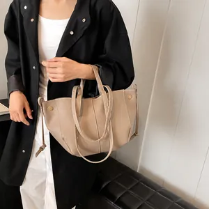 Détail du sac cabas en cuir grainé beige avec cordon de serrage et boucle dorée