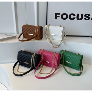 Close-up of quilted crossbody bags with V-shaped stitching and golden metal hardware detail