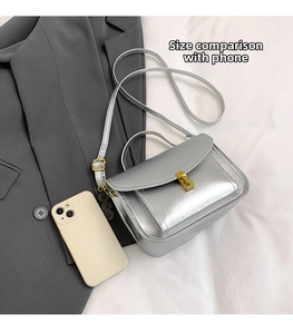 Comparaison de taille du sac bandoulière argenté avec smartphone et fermoir en métal doré