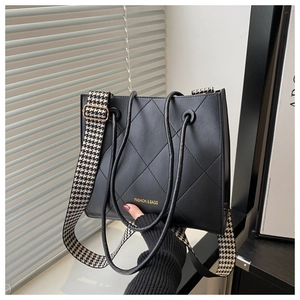 Détail du grand sac cabas noir matelassé avec sangle pied-de-poule et logo doré