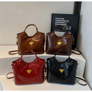 Detail view of four vintage oil wax leather tote bags in brown, coffee, red, and black