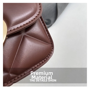 Vue macro de la texture en cuir matelassé marron et boucle en métal doré du sac à main
