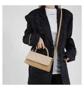 Détails du sac bandoulière avec rabat tissé beige et finition en cuir de couleur kaki