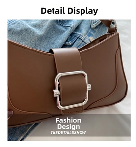 Close-up of caramel leather shoulder bag with vintage silver buckle and fine stitching