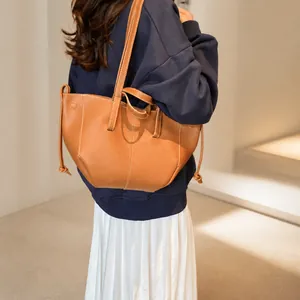 Détail du sac cabas en cuir caramel avec surpiqûres blanches et cordon de serrage