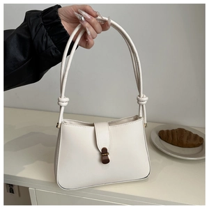 White faux leather shoulder bag featuring a unique knotted handle and vintage metal clasp