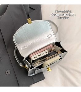Sac bandoulière argenté avec fermoir doré montrant un intérieur spacieux pour vos objets