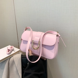 Pink minimalist leather square handbag with golden horseshoe buckle held by model