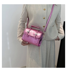 Detail of metallic magenta glossy mini crossbody bag with wrinkled texture and silver buckles
