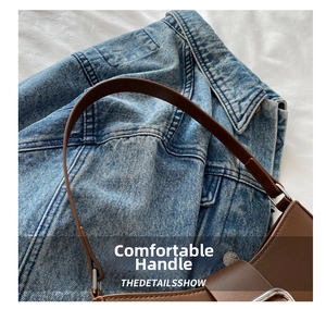 Close-up of the silver metal buckle and brown leather strap on a minimalist baguette bag