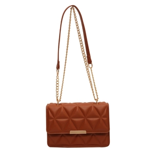 Brown quilted crossbody bag with golden metal trim and triangle pattern on white background