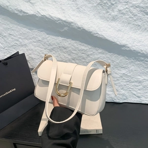White baguette shoulder bag with gold horseshoe buckle and adjustable strap in minimalist style