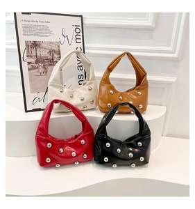 Gros plan de quatre sacs à main cloutés en blanc marron rouge et noir élégants