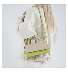 Détail du sac à bandoulière en cuir vert avec rabat tissé beige et garniture dorée