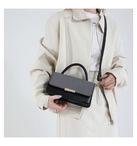 Détail du petit sac carré bicolore avec rabat à texture tissée et boucle en métal doré