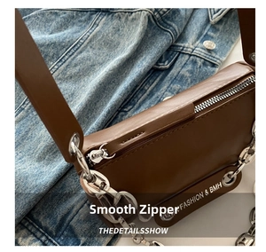 Detail of dark brown leather bag with silver chain and Fashion & BMH letter printing
