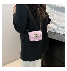 Détail du mini sac bandoulière matelassé rose avec fermoir cœur doré sur modèle