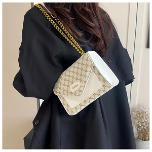 Détail du sac à bandoulière vintage avec motif monogramme et plaque en métal mode