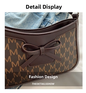 Detail of dark brown leather handbag with letter monogram print and leather bow decoration