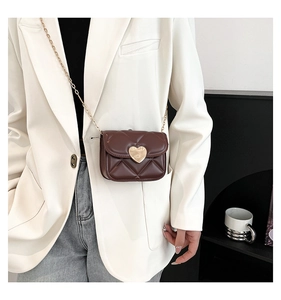 Détail d'un petit sac carré matelassé marron chocolat avec boucle coeur dorée et chaîne