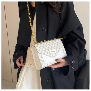Détail du sac bandoulière blanc avec motif C entrelacé et bandoulière chaîne dorée
