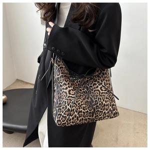 Detail of leopard print tote bag featuring a black drawstring bow on a stylish shoulder bag
