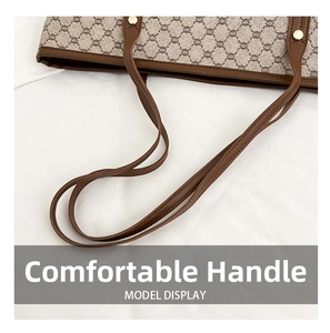 Close-up of leather handles and gold rivets on a vintage canvas tote bag