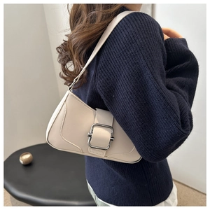 Detail view of cream white PU leather underarm bag with a large silver square metal buckle