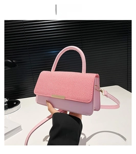 Détail du sac à bandoulière rose avec rabat en tricot et garniture en métal doré