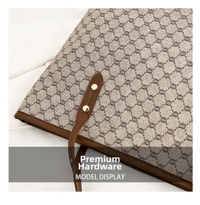 Close-up of vintage canvas tote bag with brown leather trim and golden metal rivets